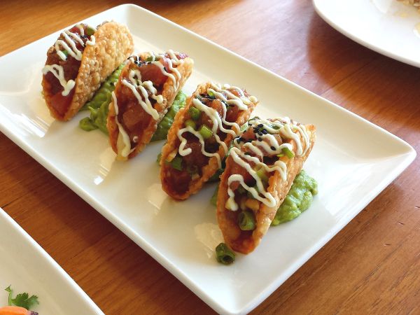 Close-up of poke tacos filled with diced raw fish, fresh vegetables, and garnishes in a crispy taco shell